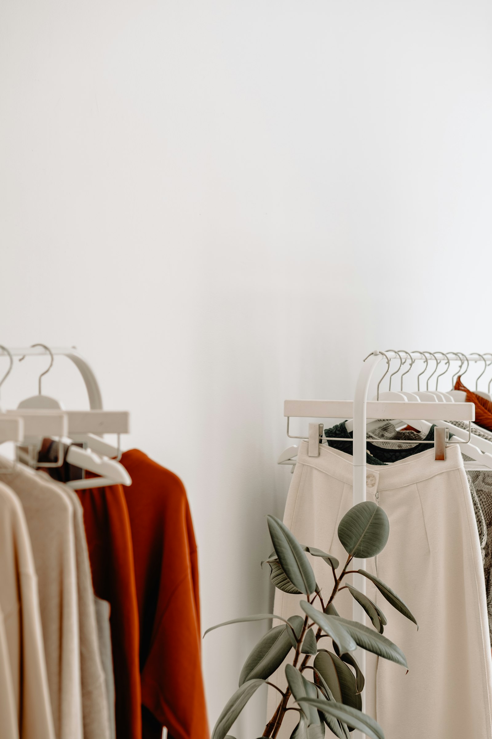 Percheros con ropa en tonos neutros en una tienda
