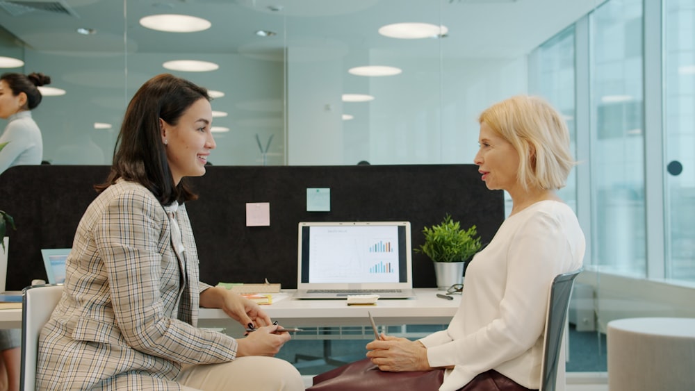 Dos compañeras conversan abiertamente en la oficina