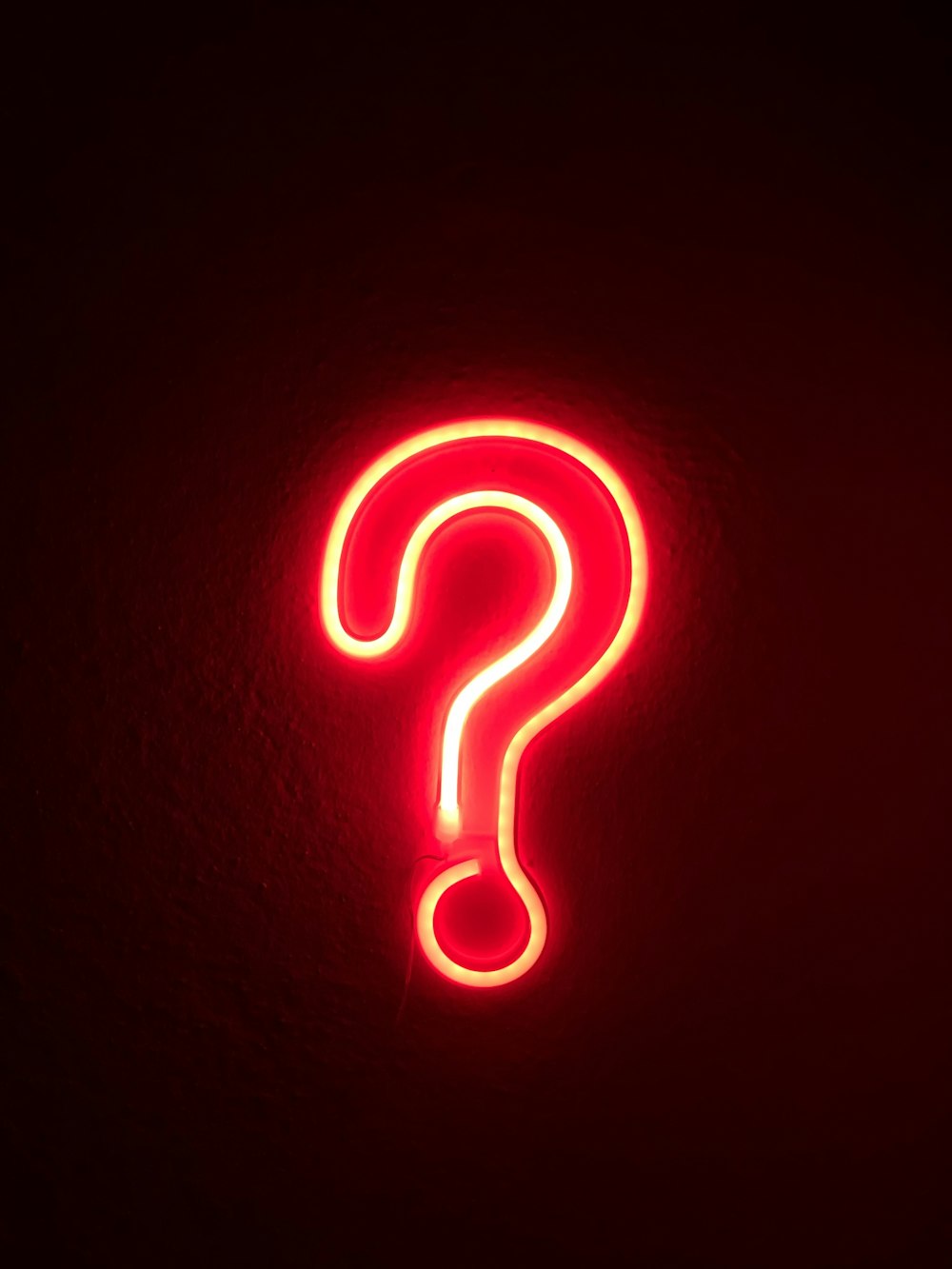 Signo de interrogación de neón en una pared